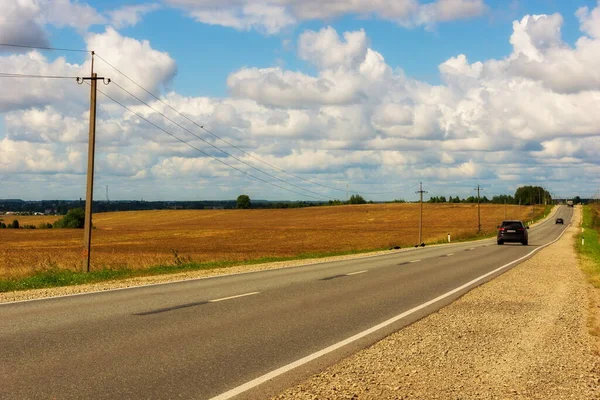 Yüksek hızlı asfalt yolu olan manzara kırsal alanlar arasında kümülüs bulutları gökyüzünde