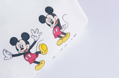 Minsk Belarus, 9 Nisan 2020: Kadın moda kıyafetleri beyaz arka planda yatıyordu. Düz kapüşonlu 3 tane Mickey Mouse karakterli fotokopi yeri olan. Beyaz pamuk kumaş giyim arka planı.