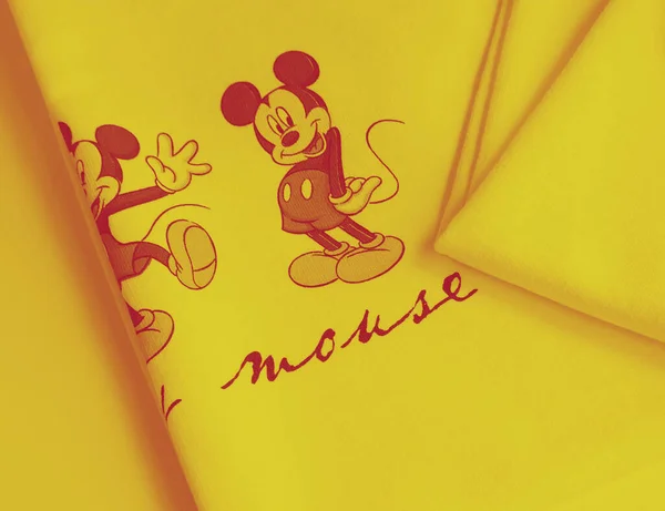 Minsk Belarus, 9 Nisan 2020: Kadın moda kıyafetleri düz sarı tonlu arka plan manzaralı. Düz kapüşonlu 3 tane Mickey Mouse karakterli fotokopi yeri olan. Sarı tonlu pamuk kumaş giyim arka planı.
