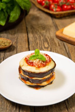 Fırında patlıcan, mozzarella ve sade ahşap bir masada malzemelerle parmesan yığını. Kapatın. Seçili odak.