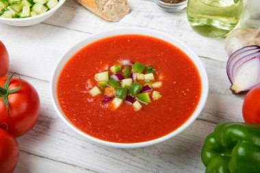 Gazpacho. Geleneksel İspanyol domates çorbası, taze domates, salatalık, sade ahşap masa üzerinde dolma biber..