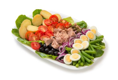 Beyaz arka planda izole edilmiş beyaz dikdörtgen salata kasesinde geleneksel Nicoise salatası..