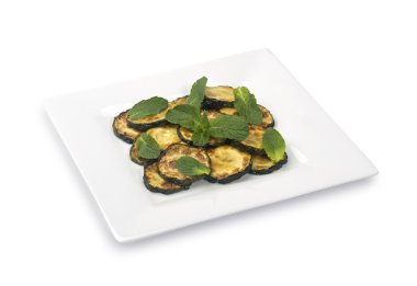 Beyaz zemin üzerine nane yaprağı ile sotelenmiş kabak