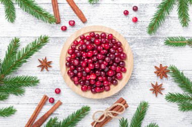 Tahta kasede çiğ yaban mersini, baharat ve hafif ahşap arka planda köknar dalları. Üst Görünüm - Resim