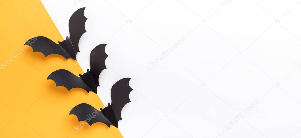 Horizontal Halloween banner. Black paper bats on yellow and white background. Flat lay, top view, copy space - Image