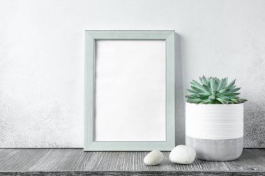Evin içi ahşap masada seramik kapta echeveria bulunan fotoğraf çerçevesiyle süslenmiş. Evde bahçıvanlık. Şablon - Resim