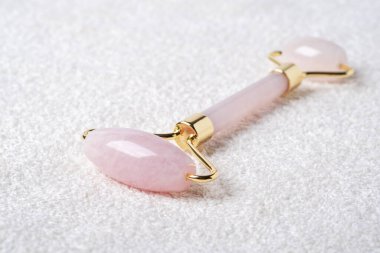 Rose Quartz yeşim taşı havlunun üzerinde. Yüz bakımı için masaj aleti, SPA güzellik tedavisi konsepti. Yakın plan - Resim