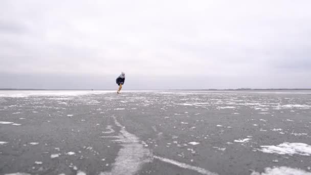 Девушка Прыгает Фигурном Катании Замерзшему Озеру Облачно Холодный Зимний День — стоковое видео