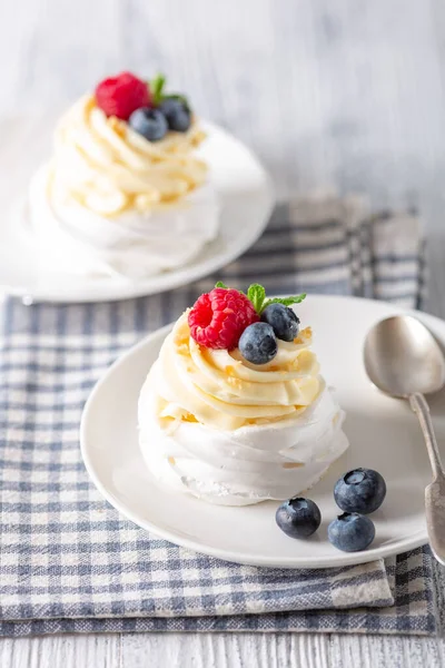 Tort delicios de desert Pavlova cu frișcă și fructe de pădure proaspete pe placă albă — Fotografie, imagine de stoc