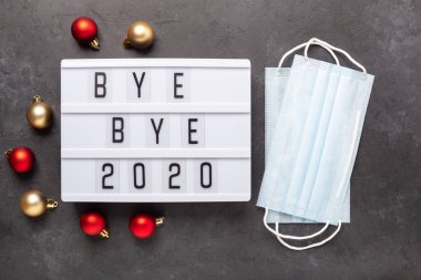 Elveda mesajı içeren ışık kutusu. 2020, karanlık arka planda tıbbi maske. Üst Manzara. Yeni yıl kutlaması. Mutlu yıllar 2021 kavramları - Görüntü