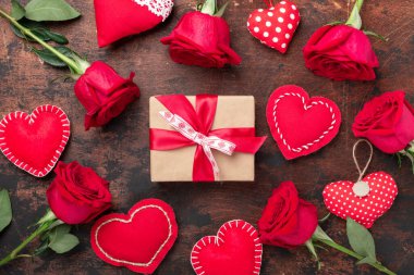 Kırmızı güller, hediye kutusu ve ahşap arka planda dekoratif tekstil kalpleri. Sevgililer Günü tebrik kartı - Görüntü
