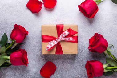 Red rose flowers, gift box on stone background Valentine's day greeting card Copy space Flat lay