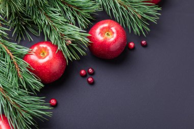 Noel kompozisyonu köknar dalları ve siyah ahşap arka planda kırmızı elmalar - görüntü