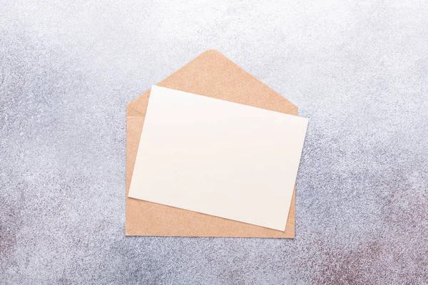 Blanco Papier Met Envelop Grijze Achtergrond Bovenaanzicht Kopieerruimte — Stockfoto