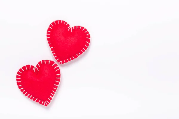 Dos corazones textiles rojos sobre fondo blanco. El concepto de San Valentín. Copia espacio para tu texto — Foto de Stock