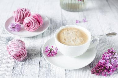 Bir buket leylak, bir fincan kahve, ev yapımı marşmelov Romantik bahar sabahı Seçici odak noktası