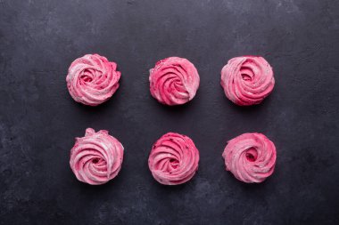 Siyah taştan arka planda ev yapımı pembe şekerlemeler.