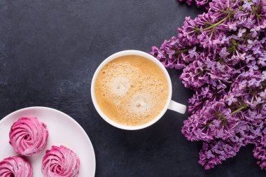 Leylak, bir fincan kahve, ev yapımı pembe marşmelov, arka planda siyah taş.
