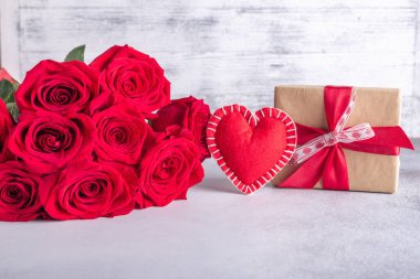 Güzel kırmızı güller, hediye kutusu ve taş arka planda dekoratif tekstil kalbi. Sevgililer Günü konsepti - Görüntü