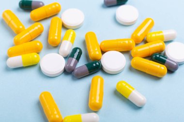 Mavi arka planda bulunan çok renkli tabletler ve haplar çeşitli ilaç tabletleri ve haplar. Sağlık hizmetleri, yakın çekim kopyalama alanı