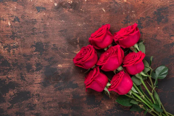 Röda ros blommor bukett på trä bakgrund Alla hjärtans dag gratulationskort. Uppfattat utrymme. Ovanifrån — Stockfoto