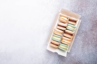 Makarnalar taş zeminde kutuda. Lezzetli Fransız kurabiyeleri. Boşluğu kopyala, üst görünüm