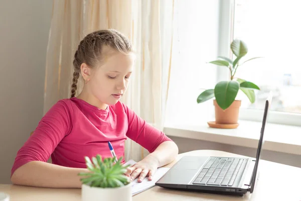Une écolière assise au bureau et utilisant un ordinateur portable. Éducation Retour à l'école — Photo