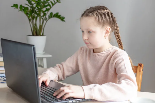 Une écolière assise au bureau et utilisant un ordinateur portable. Éducation Retour à l'école — Photo