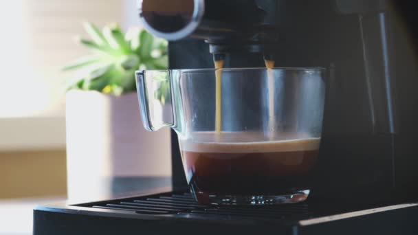 Koffiemachine maken espresso in glazen transparante koffiekop. — Stockvideo