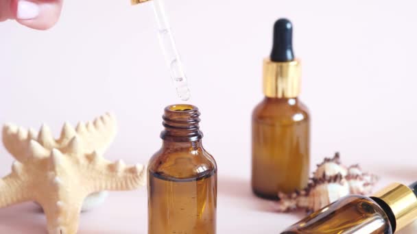 Il siero del primo piano sta gocciolando dalla pipetta. Bottiglia di vetro siero viso con pipetta, cosmetico naturale organico spa. concetto di cura della pelle — Video Stock