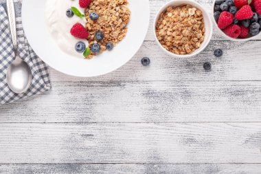 Fırında granola ve Yunan yoğurdu ile sağlıklı bir kahvaltı. Çeşitli taze böğürtlenler