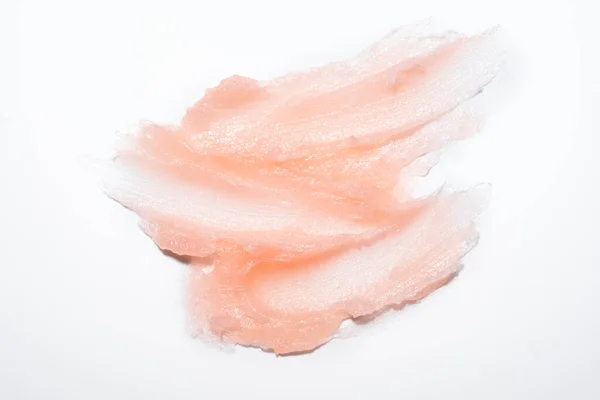 Amostra de produto cosmético cremoso gel textura mancha no fundo branco. Esfoliação cosmética de textura rosa para rosto e corpo — Fotografia de Stock