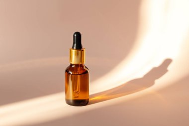 Gerekli yağ ya da serum içeren cam şişe, sert ışık, derin gölgeler, kopyalama alanı. Cilt bakımı kavramı