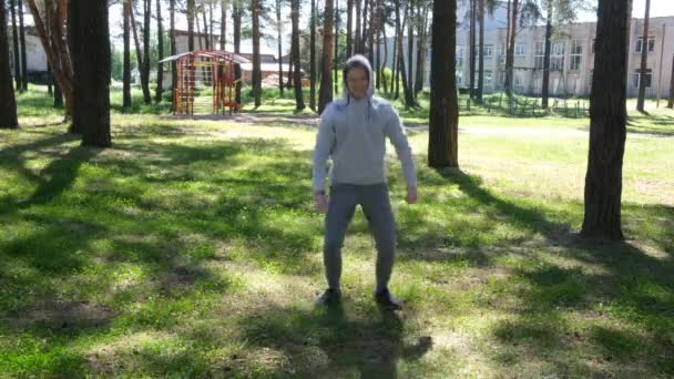 森林公園で運動をしてる独身青年ストリートワークアウト。外のフィットネス。Covid-19予防のための単独演習 — ストック動画