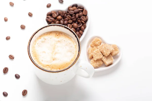 Kubek z kawą i sercowymi talerzami z ziarnami kawy i brązowym cukrem na białym tle. Widok z góry — Zdjęcie stockowe