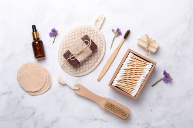 Beyaz mermer zemin üzerinde banyo araçları, üst görünüm, kopyalama alanı. Günlük vücut bakım konsepti, doğal banyo ürünleri