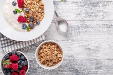 Fırında granola ve Yunan yoğurdu ile sağlıklı bir kahvaltı. Çeşitli taze böğürtlenler