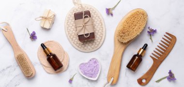 Beyaz mermer zemin üzerinde banyo araçları, üst görünüm, kopyalama alanı. Günlük vücut bakım konsepti, doğal banyo ürünleri