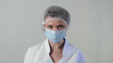 Tıbbi maske takan yorgun beyaz kadın doktor ya da hemşire portresi. Coronavirus önleme kavramı