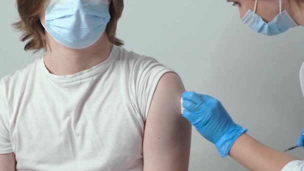 Medical nurse is making a vaccine injection to a male patient indoor. Coronavirus vaccination concept. Slow motion — Stock Video