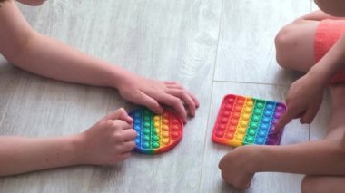 Çocuk ve Gril, Morden 'ın silikon oyuncağına baloncuk yapıştırıyor. Stres önleyici oyuncak popit. Yakın plan. Yavaş çekim