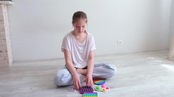 Adolescente jouant avec des jouets en silicone morden popit et fossette simple. Tendance 2021. Jouet anti-stress pop it. Mouvement lent — Video