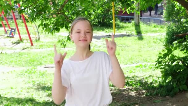 Portrét dospívající dívky tančící a usmívající se. Dívka v městském parku za slunečného letního dne. Štěstí a bezstarostný koncept — Stock video
