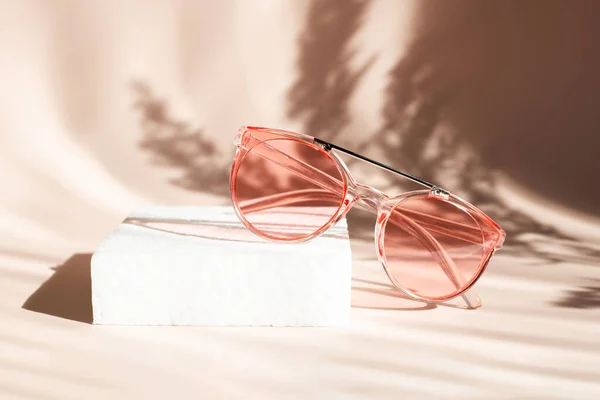 Modne różowe okulary przeciwsłoneczne na tle kwiatów. Pampas trawa naturalne cienie na beżowym tle. Koncepcja sprzedaży letniej — Zdjęcie stockowe