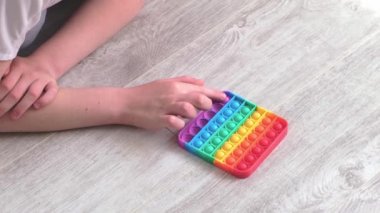 Gril, Morden silikon oyuncağına baloncuk bastırıyor ve patlatıyor. Stres önleyici oyuncak popit. Yakın plan. Yavaş çekim