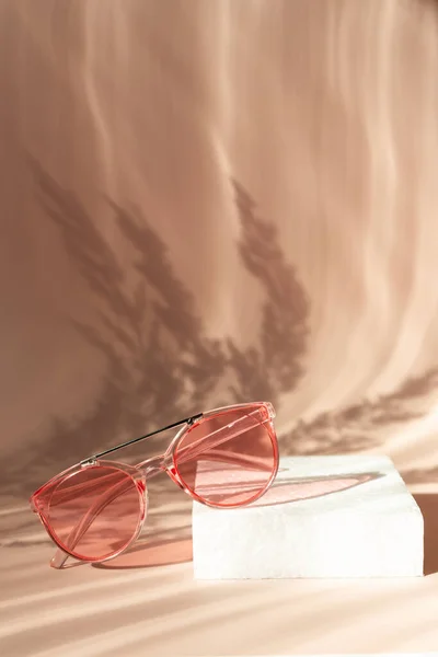 Modne różowe okulary przeciwsłoneczne na tle kwiatów. Pampas trawa naturalne cienie na beżowym tle. Koncepcja letniej akcesorium. Pionowe — Zdjęcie stockowe