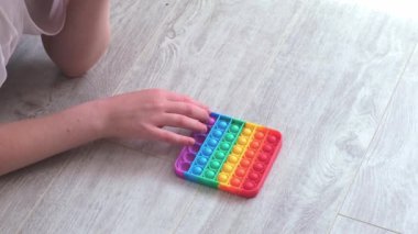 Gril, Morden silikon oyuncağına baloncuk bastırıyor ve patlatıyor. Stres önleyici oyuncak popit. Yakın plan. Yavaş çekim
