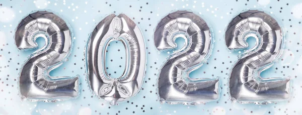 Silberne Luftballons in Form von Ziffern und Konfettisterne auf blauem Hintergrund. Frohes neues Jahr — Stockfoto