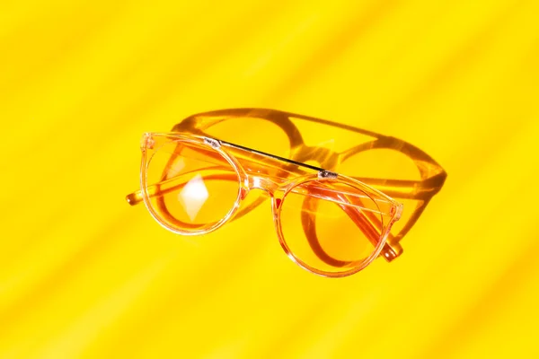 Modne różowe okulary przeciwsłoneczne na żółtym tle. Koncepcja akcesoriów letnich — Zdjęcie stockowe