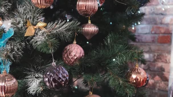 Versierde kerstboom met bloemenslinger verlichting. Close-up van nieuwjaarsdennenboom met decoraties en glinsterende lichtjes — Stockvideo